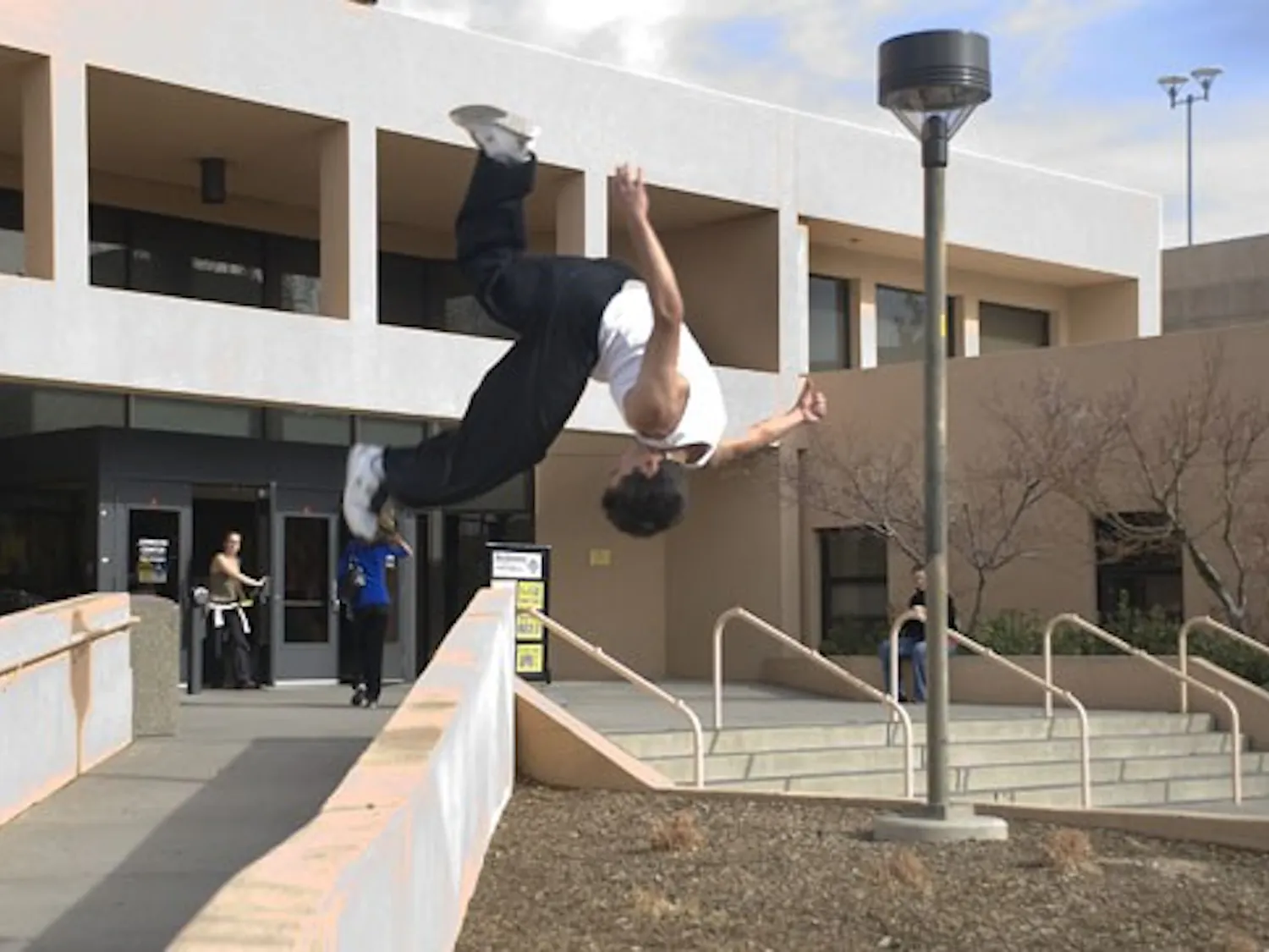 Zack Wright somersaults from a walkway outside Johnson Gym on Wednesday.