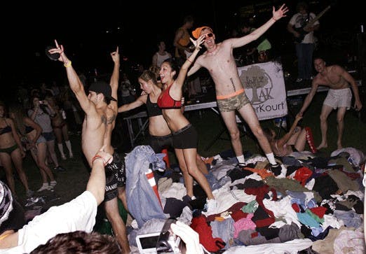 Students celebrate on top of a pile of clothes at Johnson Field on Thursday. Participants donated their clothes to Joy Junction through the first annual UNM "Undie Run."