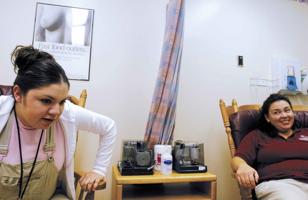 UNM Hospital outpatient clerk --Natasha Aragon, left, gets up from a seat in the Health Sciences Center's new Employee Lactation Station during its grand opening on the third floor of the hospital Friday. The station is equipped with breast pumps, center,
