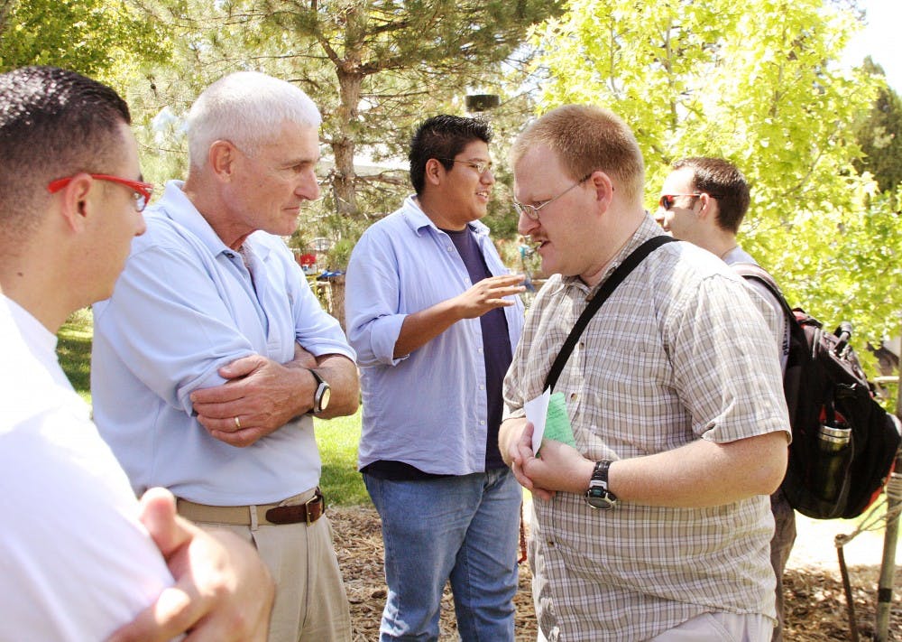	Allen Weh listens to a student talk about education in New Mexico while they stand near the Duck Pond on Thursday. The UNM College Republicans brought Weh and five other Republican politicians to campus for Student Organization Day.