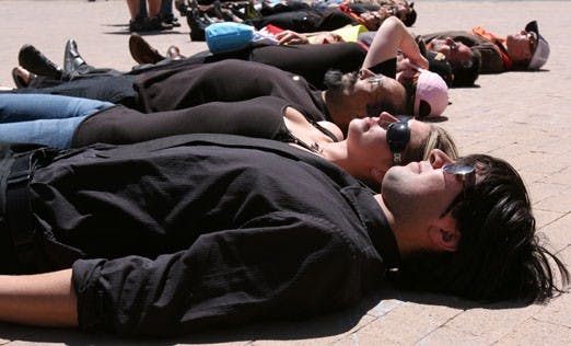 Students Victor VanDoren and Elyse Forbes lie down to protest lax gun laws on the one-year anniversary of the Virginia Tech shootings. 
