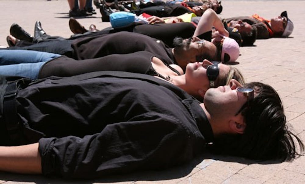 Students Victor VanDoren and Elyse Forbes lie down to protest lax gun laws on the one-year anniversary of the Virginia Tech shootings. 