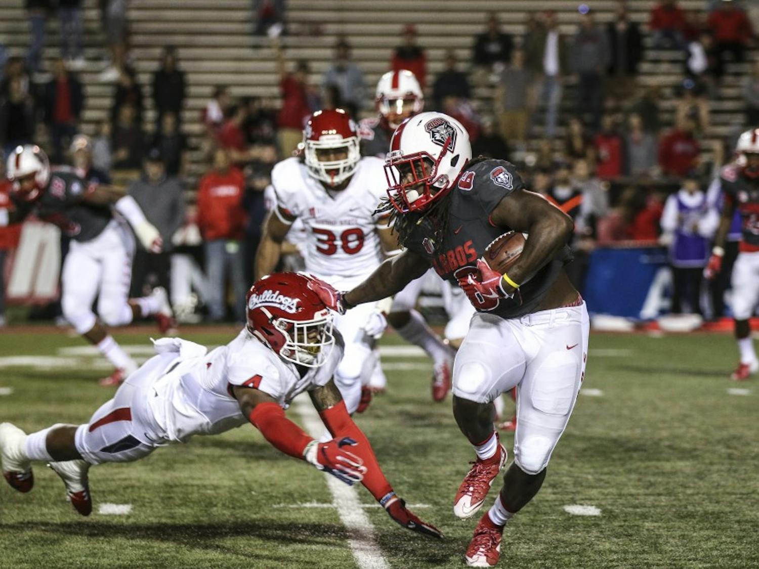 De’John Rogers (#6) stiff-arms an on-coming tackler from Fresno State during Saturday’s game. UNM was defeated 38-7. &nbsp;