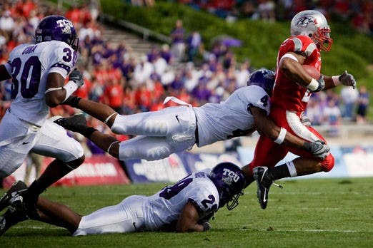 UNM tailback Rodney Ferguson is tripped up by a group of TCU defenders. Ferguson had 64 yards on 18 carries in the Lobos' 26-3 loss to TCU. 