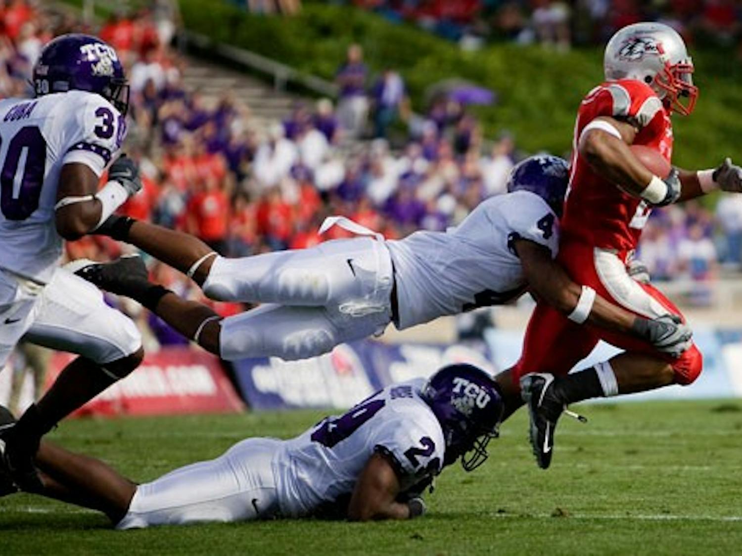 UNM tailback Rodney Ferguson is tripped up by a group of TCU defenders. Ferguson had 64 yards on 18 carries in the Lobos' 26-3 loss to TCU.