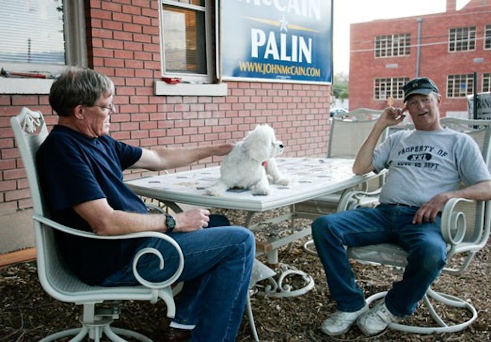 Brothers Pat Hilger, left, and Bob Hilger sit with their dog Maggie on the front porch of their house on Silver Avenue. The Hilgers have the largest McCain-Palin sign in their neighborhood. 