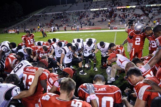In this October file photo, members of the San Diego State and UNM football teams gather at midfield to pray. Religion and athletics often intersect, as many athletes look to their faith whether winning or losing.