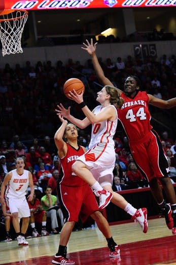 Amy Beggin shields the ball from Nebraska's Catheryn Redmon while finishing with her left hand. The Lobos handled the Cornhuskers 54-43 at the Santa Ana Star Center on Wednesday. Beggin had 25 points.