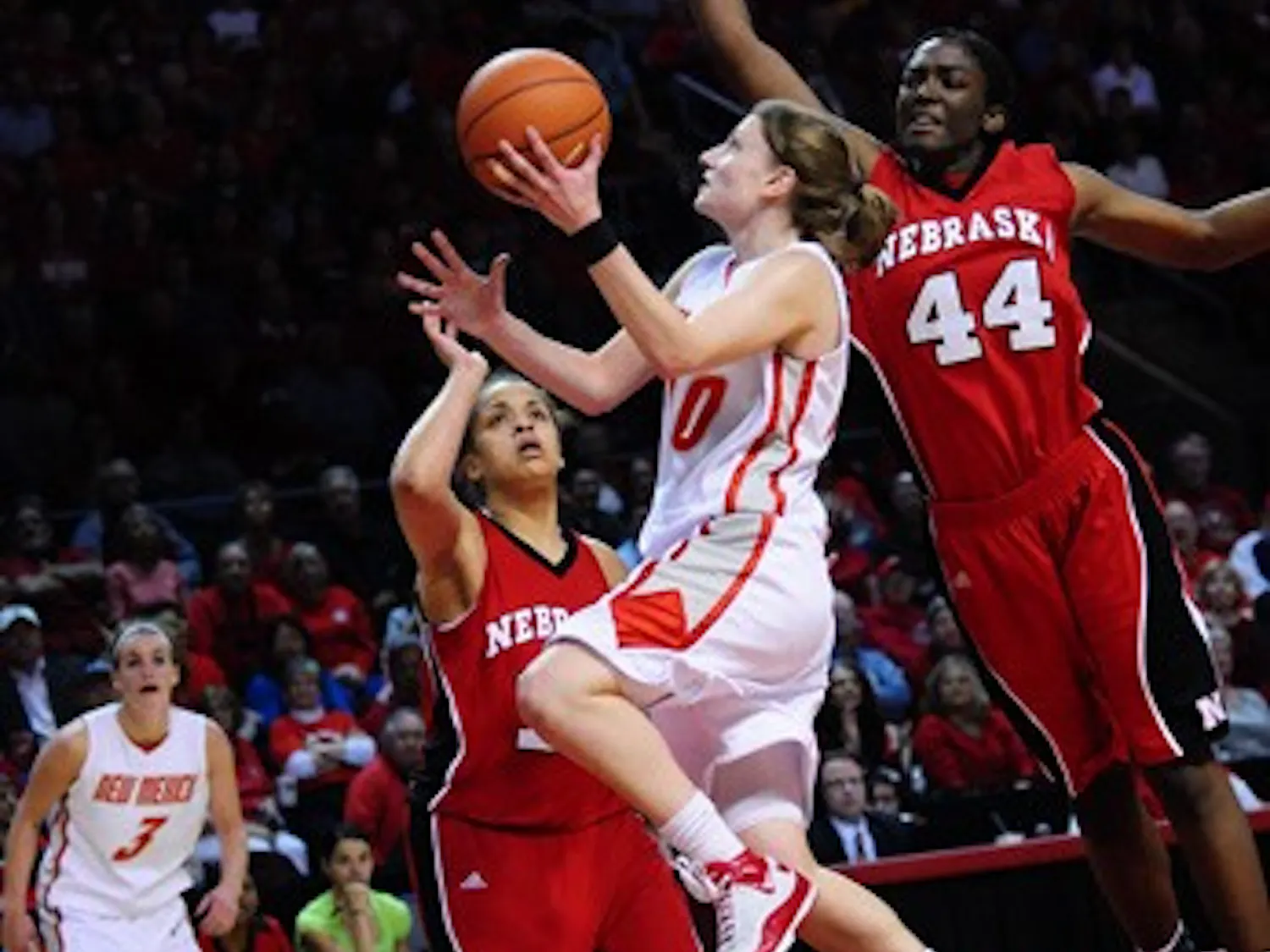 Amy Beggin shields the ball from Nebraska's Catheryn Redmon while finishing with her left hand. The Lobos handled the Cornhuskers 54-43 at the Santa Ana Star Center on Wednesday. Beggin had 25 points.