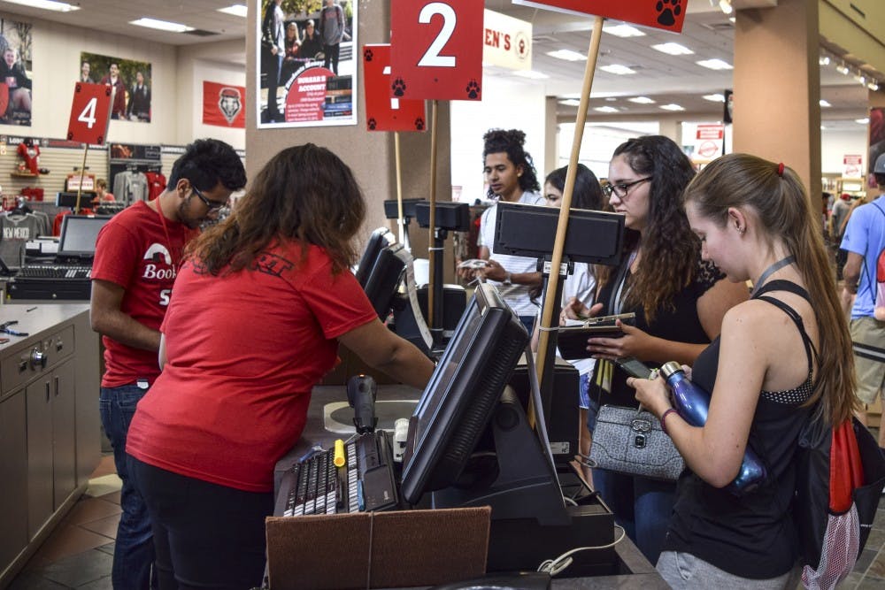 Student employees at the UNM Bookstore help customers at designated registers Friday afternoon. Student employees have many variables such as how many hours they work, skill and how much money is in a department's budget, to determine their pay.