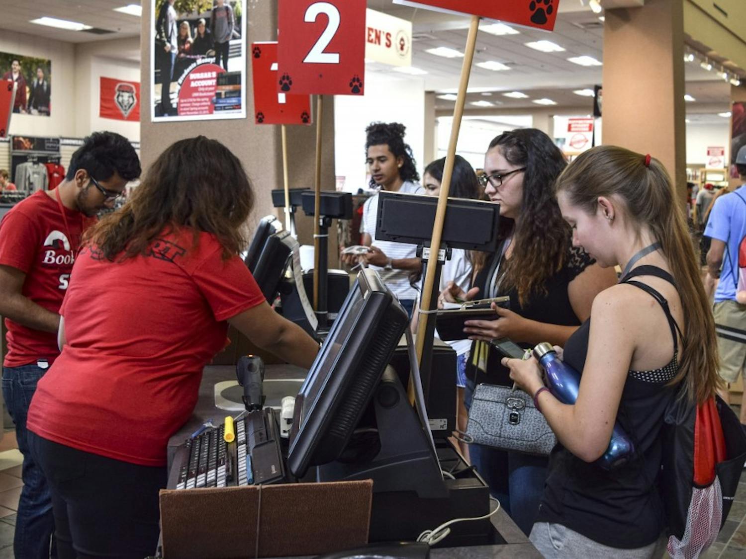 Student employees at the UNM Bookstore help customers at designated registers Friday afternoon. Student employees have many variables such as how many hours they work, skill and how much money is in a department's budget, to determine their pay.