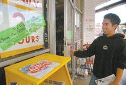 Student Adriano Lujan looks at a sign in front of the Frontier Restaurant on Wednesday advising customers of its reduced weekend hours. 