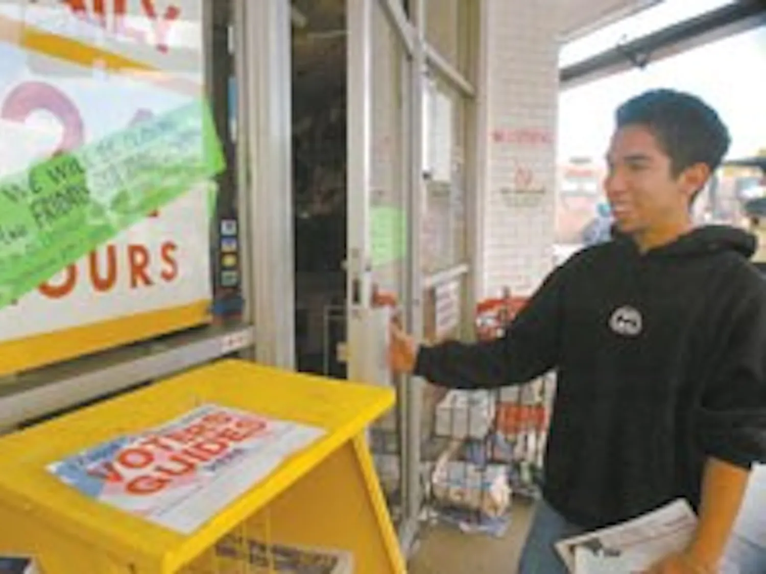 Student Adriano Lujan looks at a sign in front of the Frontier Restaurant on Wednesday advising customers of its reduced weekend hours.