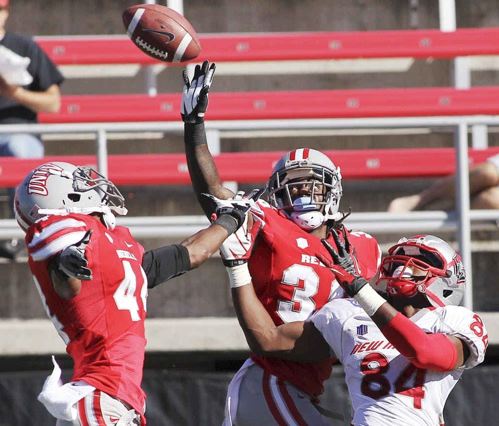 	UNLV defensive backs Sidney Hodge, center, and Kenny Keys defend a pass intended for UNM wide receiver Ty Kirk during the game Saturday in Las Vegas, Nev. The Lobos went on to lose 35-7, their third consecutive loss. 