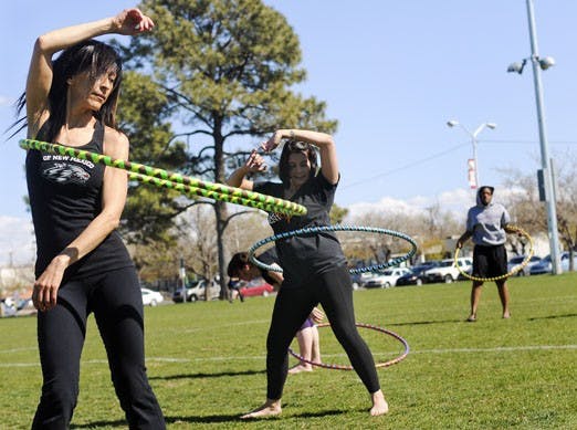 Pilates instructor Gina Pomo, left, and student Lily Robles exercise on Johnson Field on Monday. Pomo hopes to start a Hula-hoop class.