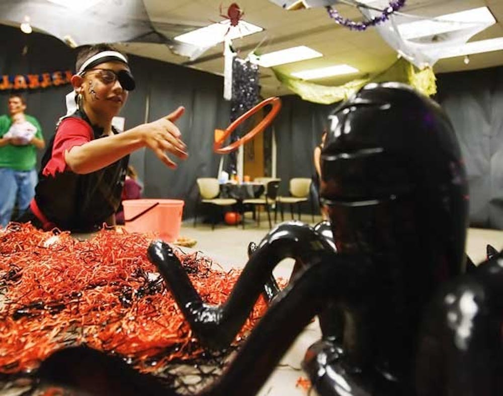 Philip Campos plays ring toss during the Juvenile Diabetes Research Foundation's Halloween Carnival at the UNM College of Pharmacy. 