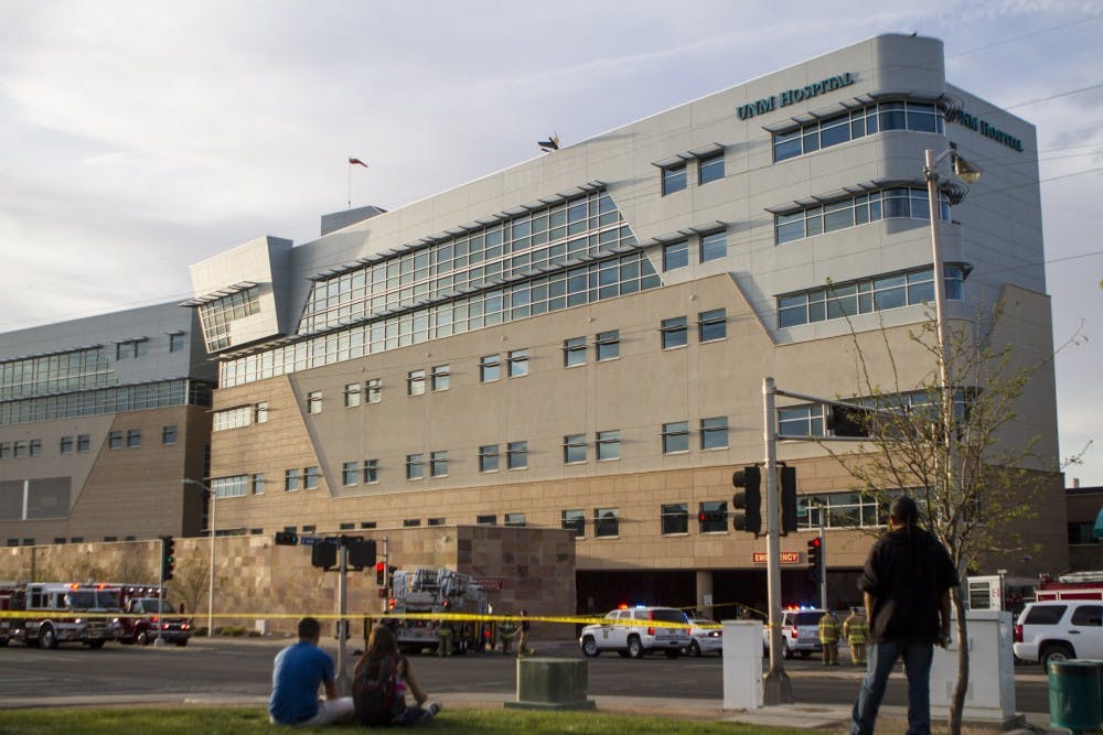 Onlookers watch from a safe distance as emergency crews unmount from a ladder truck