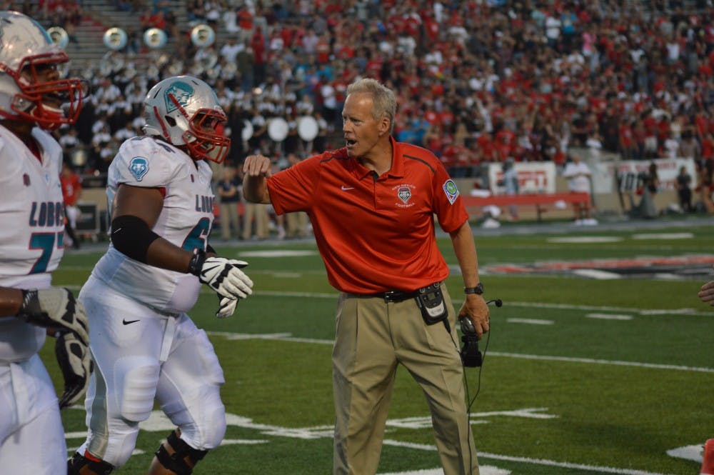 UNM Head Football Coach Bob Davie congratulates a football player after a play on Sept. 24, 2014 during a game against Fresno at University Stadium.