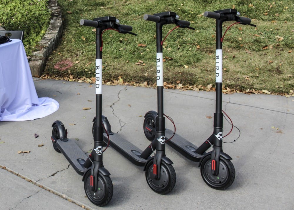 Bird scooters are lined up near the UNM Duck Pond.