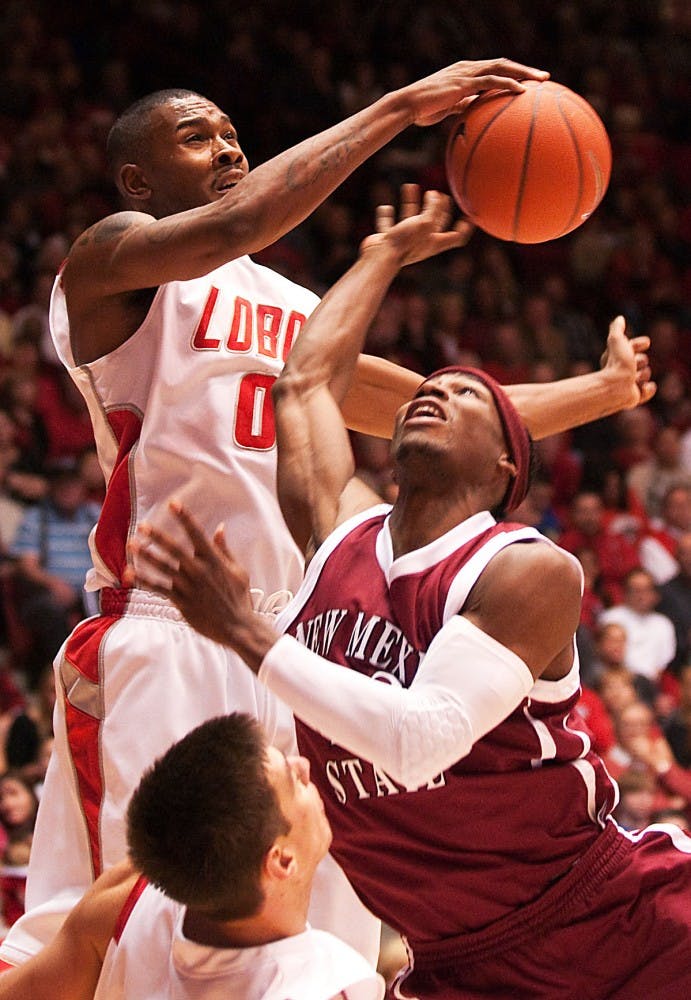 	Forward A.J. Hardeman blocks a shot by NMSU’s Jonathan Gibson in the Lobos’ 75-58 rout over the Aggies on Saturday at The Pit. UNM (8-0) is still undefeated.