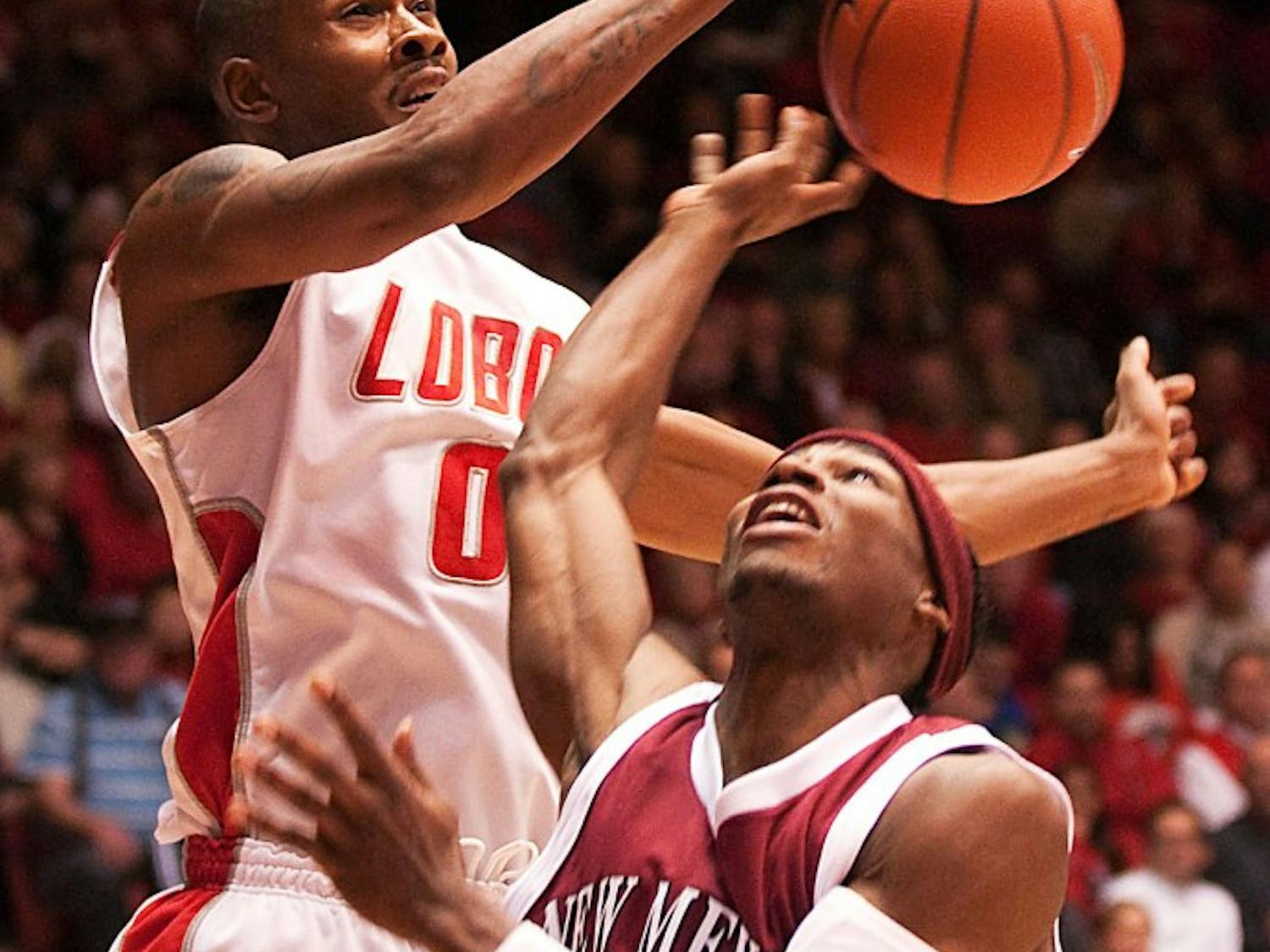 	Forward A.J. Hardeman blocks a shot by NMSU’s Jonathan Gibson in the Lobos’ 75-58 rout over the Aggies on Saturday at The Pit. UNM (8-0) is still undefeated.