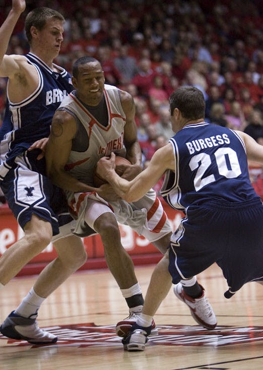 UNM guard J.R. Giddens drives on BYU's Trent Plaisted and Sam Burgess during the Lobos' 70-69 loss on Tuesday at The Pit.