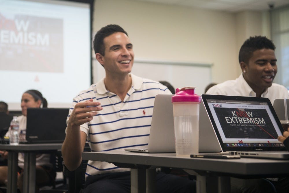 Bryan Mirabal (left) and Carlo Rogers sit with their public relations team Tuesday afternoon at the Collaborative Teaching and Learning Building. Mirabal is the public relations manager for a student run agency that started the campaign Know Extremism.&nbsp;