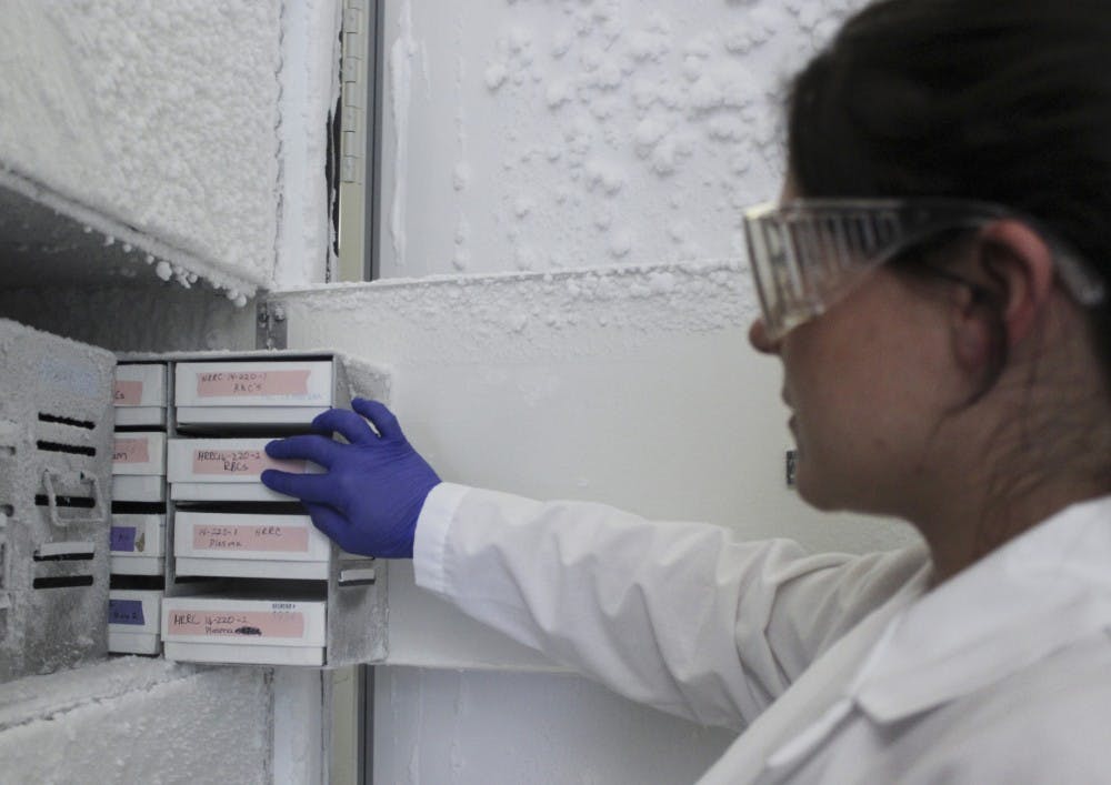 Elani Wiest, a fourth-year pre-doctoral student, pulls out various blood samples that are kept in the freezer at the HSC lab at the Research Incubator Building on March 27. Wiest is attempting to identify biomarkers that can be detected in blood drawn from smokers to assess risks of heart and vessel disease while also identifying means to prevent disease progression. 
