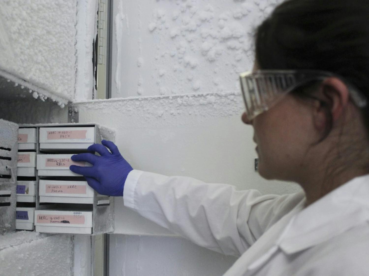 Elani Wiest, a fourth-year pre-doctoral student, pulls out various blood samples that are kept in the freezer at the HSC lab at the Research Incubator Building on March 27. Wiest is attempting to identify biomarkers that can be detected in blood drawn from smokers to assess risks of heart and vessel disease while also identifying means to prevent disease progression.
