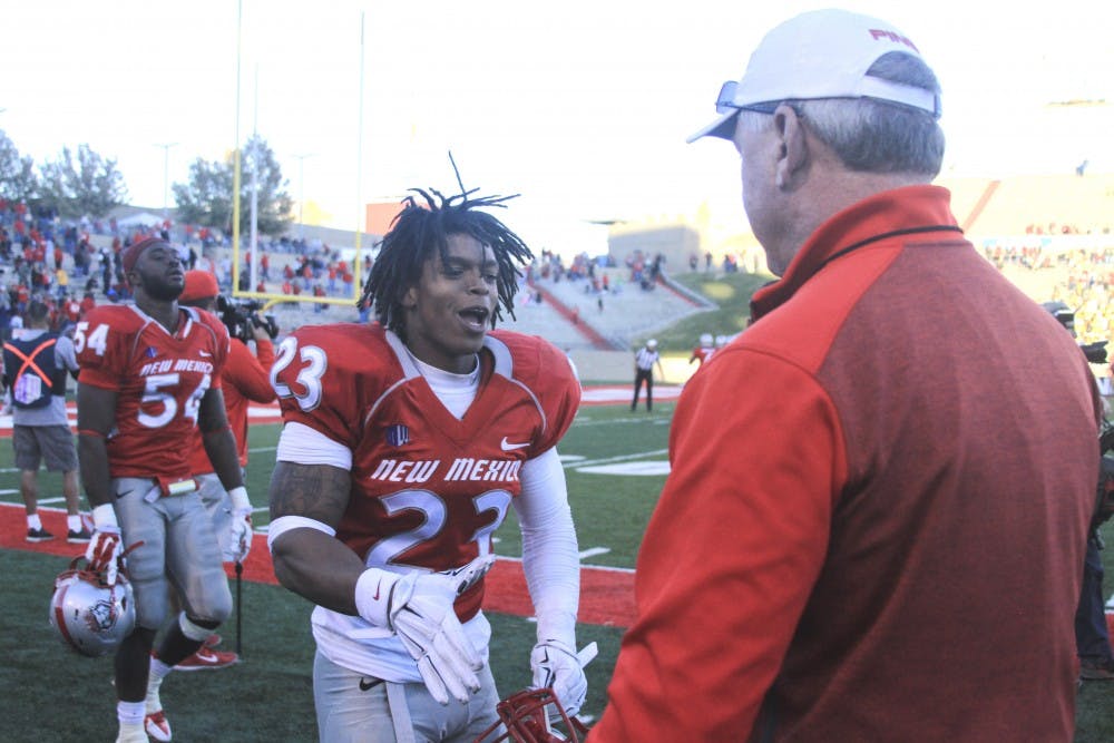 New Mexico football player Devonta Tabannah shakes hands with UNM athletic director Paul Krebs after a defensive stop in the Nov. 29 home finale against Wyoming. Krebs announced Thursday the Athletic Department will provide full cost of attendance as part of student athletes scholarships. The scholarships will now include course fees, academic-related supplies and other necessities in addition to the tuition and fees, room and board and books awarded under the current scholarships.
