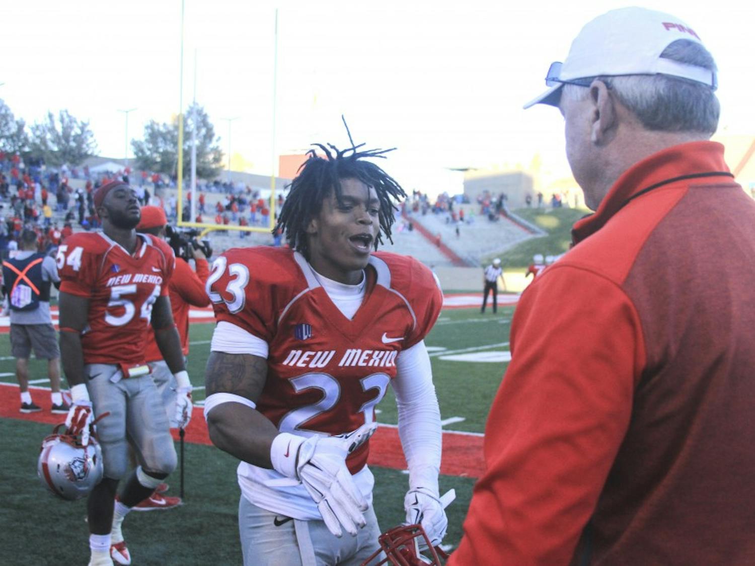 New Mexico football player Devonta Tabannah shakes hands with UNM athletic director Paul Krebs after a defensive stop in the Nov. 29 home finale against Wyoming. Krebs announced Thursday the Athletic Department will provide full cost of attendance as part of student athletes scholarships. The scholarships will now include course fees, academic-related supplies and other necessities in addition to the tuition and fees, room and board and books awarded under the current scholarships.