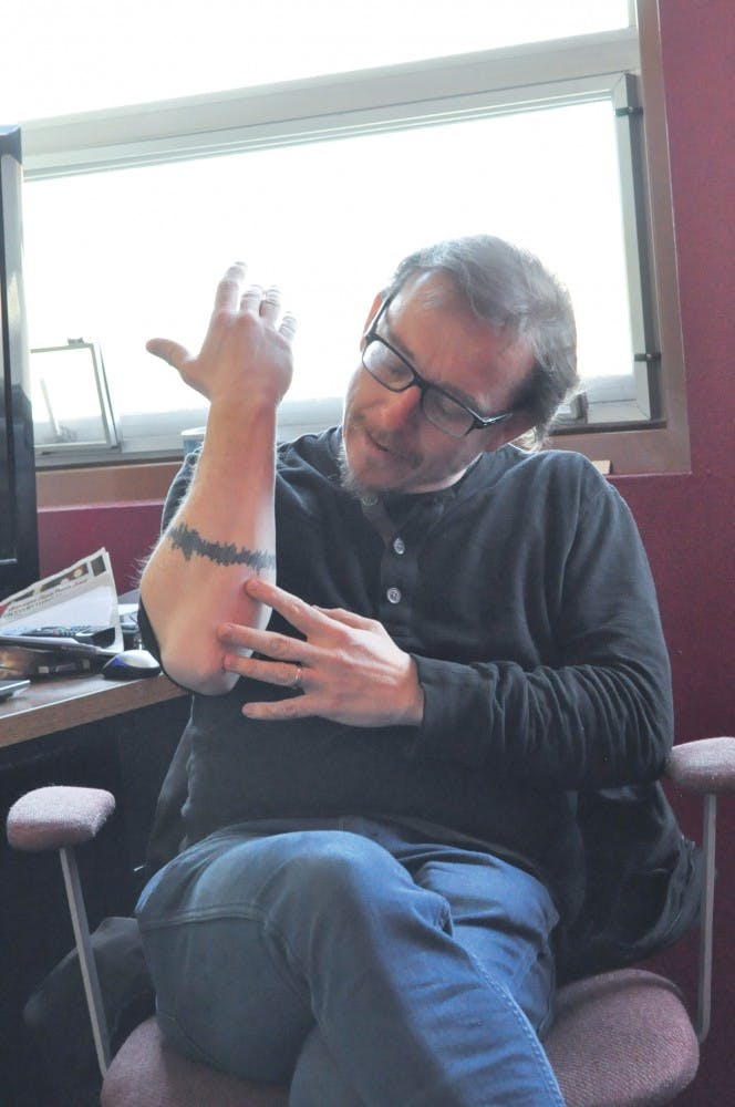 UNM Professor Lee Montgomery shows off his tattoo of a soundbite during an interview on Jan. 27.