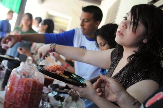 Student Jessica Perez serves traditional food during the Mexican Student Association's celebration of Raza Junta on Tuesday near Mesa Vista Hall. Raza Junta is an annual welcome-back event for Hispanic students. 