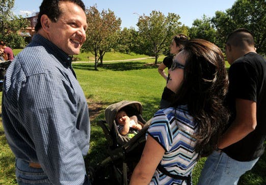 Dr. Paul Magarelli talks to one of his clients at a picnic in Jerry Cline Park on Sunday. Magarelli helped her have a child at his in vitro fertilization clinic. 