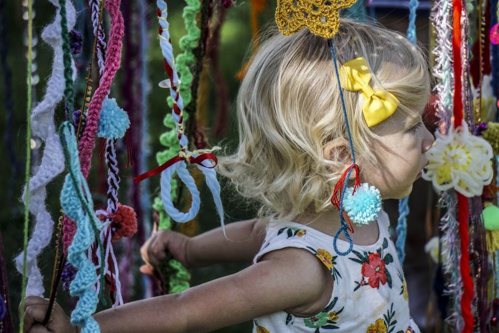 A child moves through a handmade yarn canopy at the fifteenth annual OFFcenter Folk Art Festival on Oct. 1, 2017 at Robinson Park. 