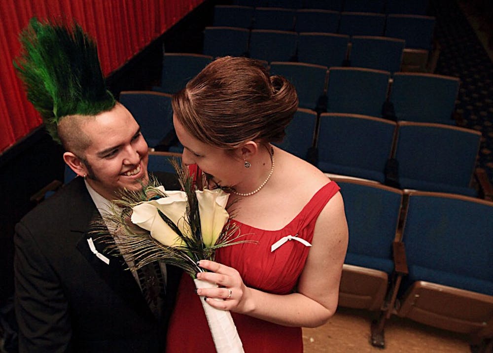 	Adam Hevey and Jessicah Adkins share a private moment after their wedding ceremony in the Guild Cinema on Jan. 9. They have known each other since they were 9 years old.