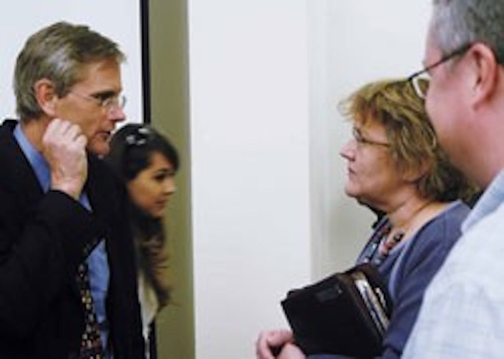 Former U.S. diplomat John Brady Kiesling, left, talks with UNM employee Gail Kaplan after his discussion Tuesday about being a diplomat and U.S. foreign relations officer in Marron Hall.