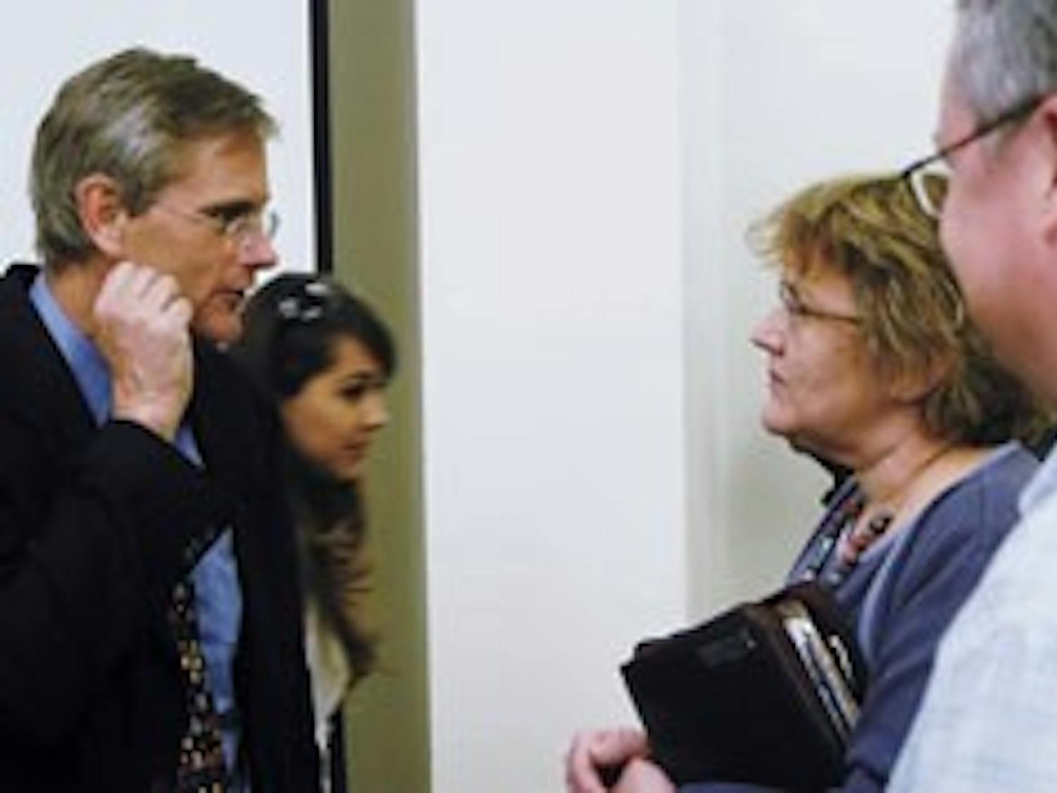 Former U.S. diplomat John Brady Kiesling, left, talks with UNM employee Gail Kaplan after his discussion Tuesday about being a diplomat and U.S. foreign relations officer in Marron Hall.
