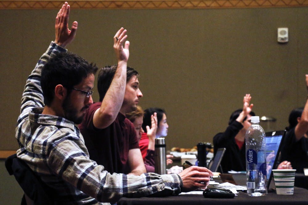 Adam Myers Gutierrez raises his hand during the voting of a budget motion Saturday morning. The meeting consisted of presentations by presidential candidates, discussions on the budget and many others topics.