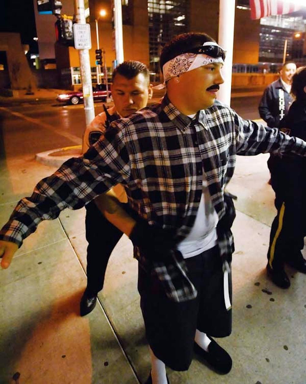 Security guard Anthony Sanchez searches Chris  Brennand in front of the Frontier Restaurant on Saturday.  