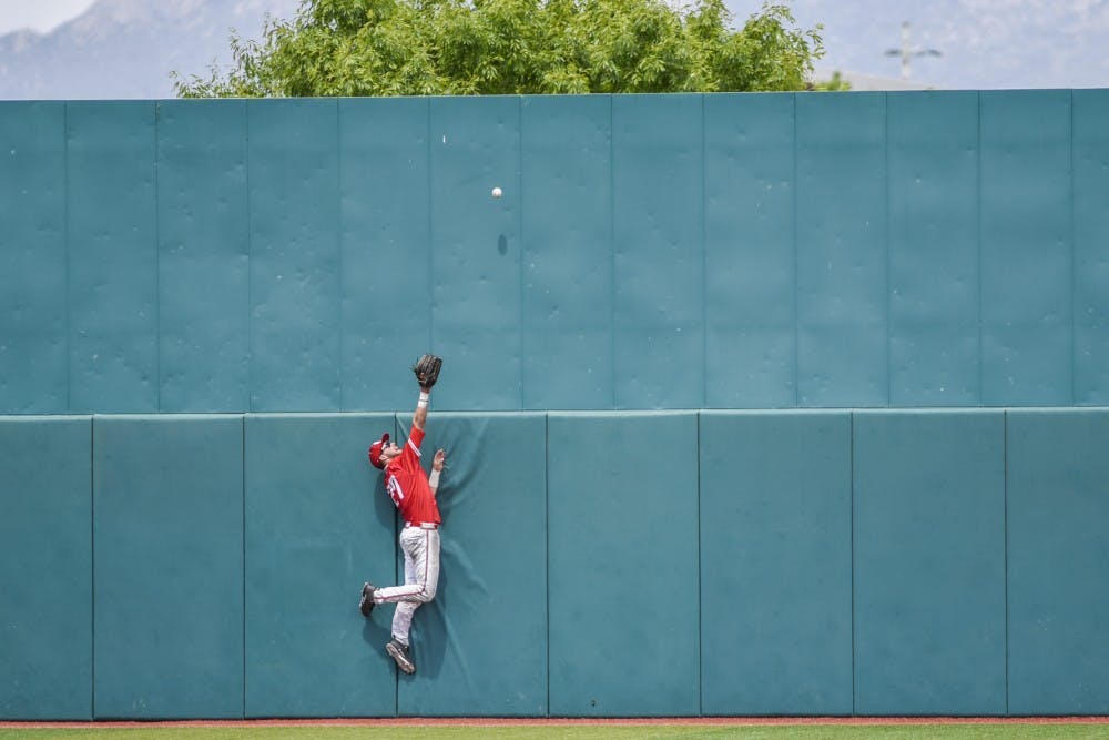Junior Luis Gonzalez leaps up against Santa Ana Star Field's far wall to catch a ball Saturday, May 6, 2017.