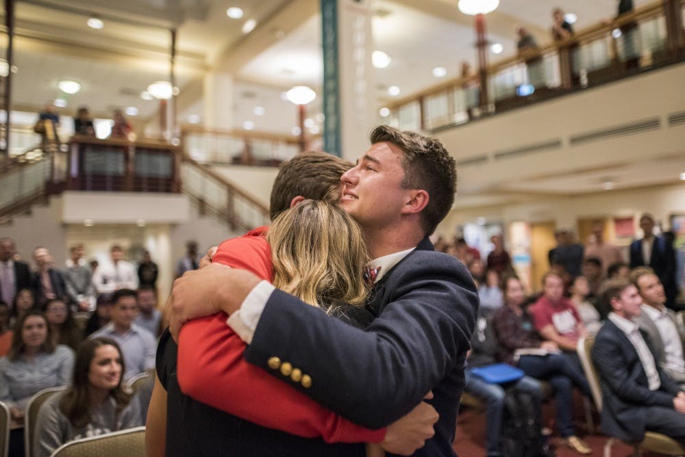 Noah Brooks, right, holds Sally Midani and Noah Michelsohn while hearing the election results for the ASUNM presidential race on Wednesday, March 29, 2017 at the UNM SUB.