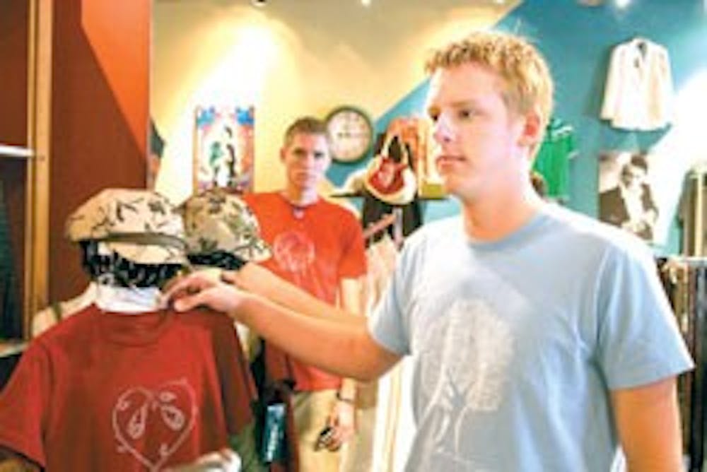 Matt Witkowski, left, and David Reis show their T-shirt designs at the clothing store Toad Road on Central Avenue.