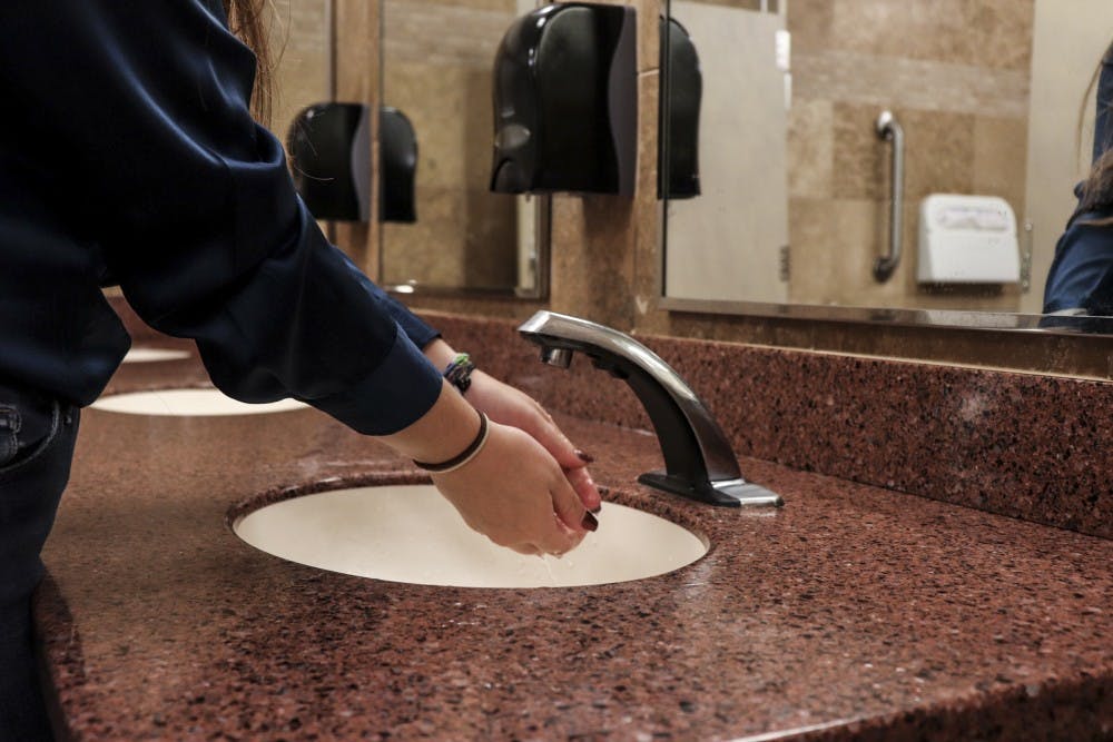 A UNM student washes their hands in a bathroom that was recently reviewed on a Twitter page that has gotten attention.&nbsp;
