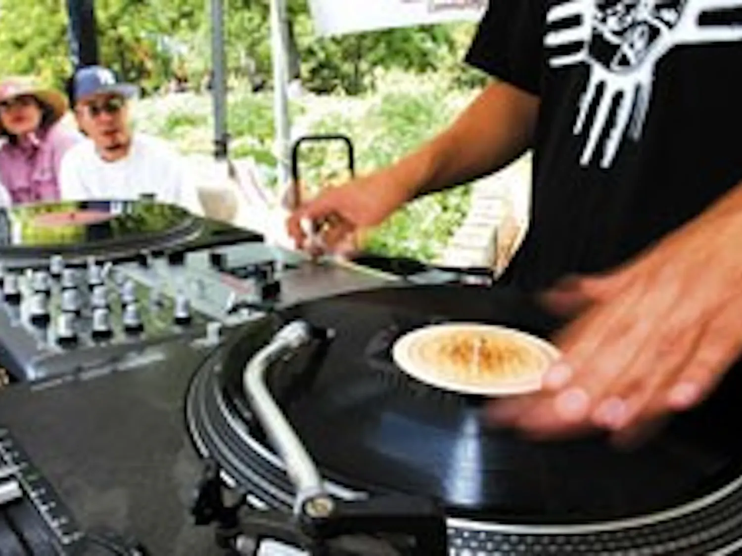 Sylas Marchiondo, aka DJ Scientific, plays music at the KUNM tent near the Duck Pond on Wednesday. KUNM Operations Manager Rachel Kaub and Bruce Chavez, aka DJ Intreeg, listen to Marchiondo, who also hosts the KUNM program "Street Beat" on Friday nights.