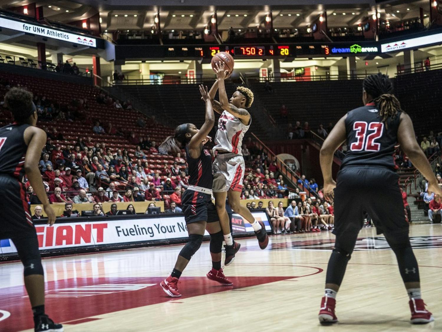 Asia Robertson shoots over Sierra DaCosta during the third quarter of Sunday’s game. Robertson recorded a double-double in a 72-65 UNM win.