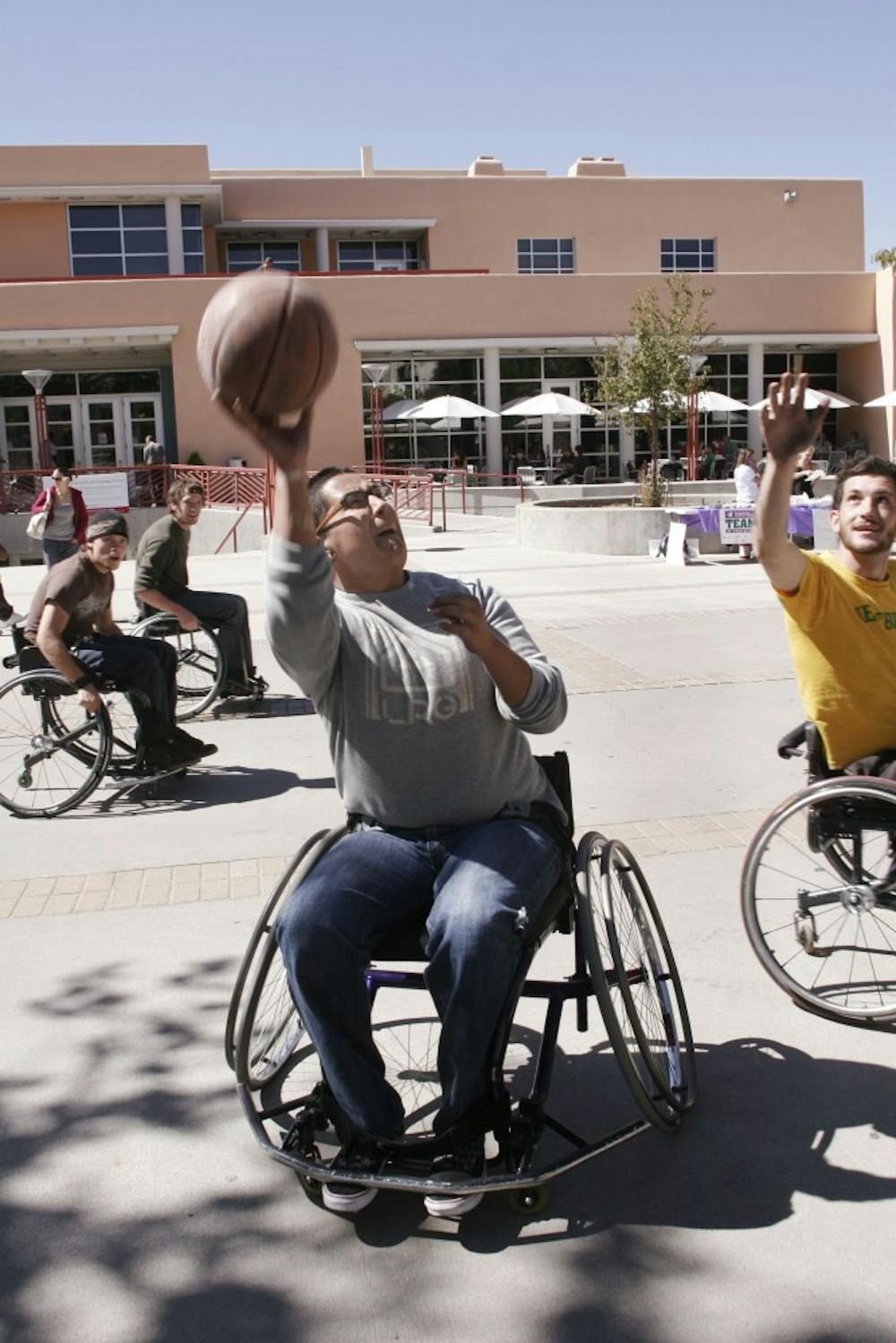 	Hector Nava, center, plays wheelchair basketball near the SUB with Ryan Johnson, right, during Disability Awareness Day on Friday. The event, hosted by the Associated Students for Empowerment, featured a blindfold obstacle course and information booths.