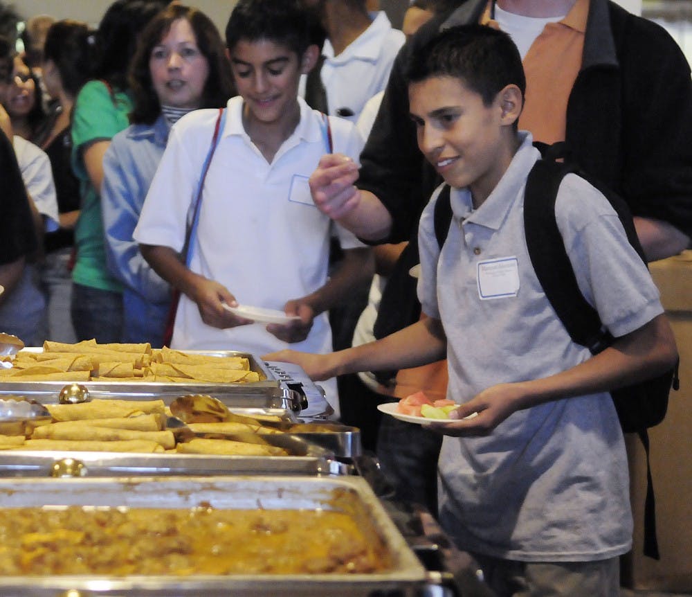 	Middle school student Marcos Alonso gets taquitos Monday in the SUB ballrooms during El Centro de la Raza’s 40th anniversary celebration.  Middle and high school students attended the celebration as part of El Centro’s attempt to increase enrollment of Hispanics at UNM. 