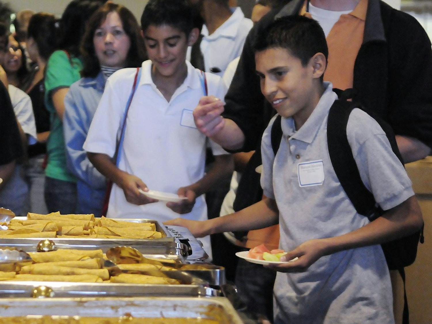 Middle school student Marcos Alonso gets taquitos Monday in the SUB ballrooms during El Centro de la Raza’s 40th anniversary celebration. Middle and high school students attended the celebration as part of El Centro’s attempt to increase enrollment of Hispanics at UNM.