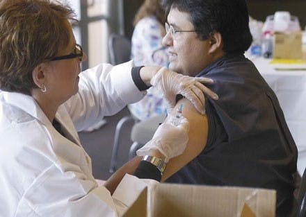 Student Health Center employee Susan Roberts gives Gabriel Huerta a flu vaccination during a shot clinic provided by Student Health Services on Tuesday in the SUB. 